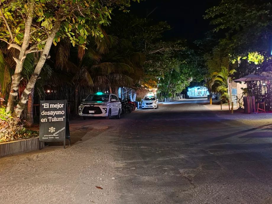 Des taxis attendent le long de la route principale, la nuit.