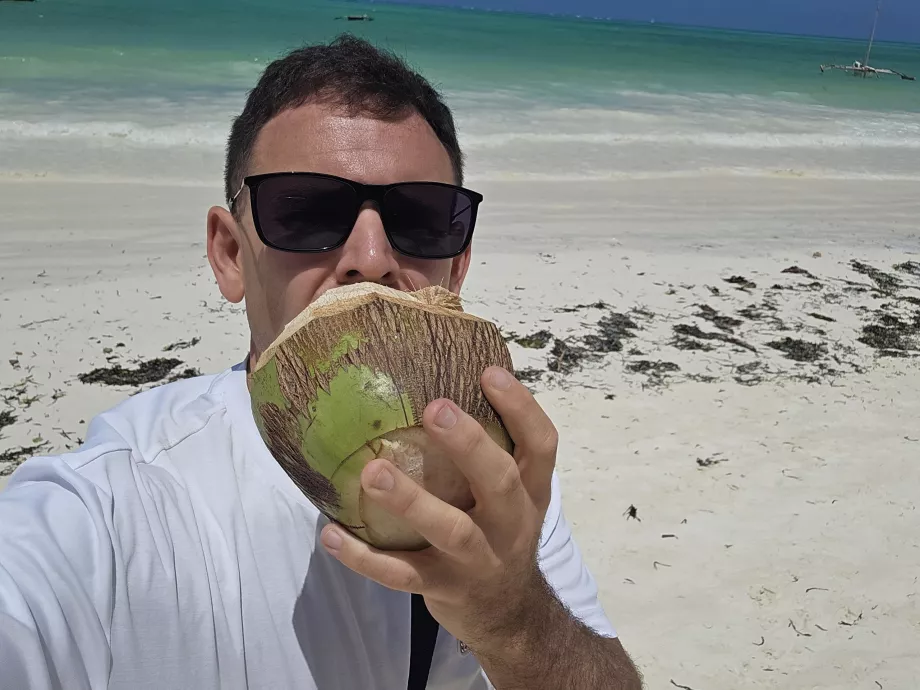 Je bois de la noix de coco sur la plage de Paje