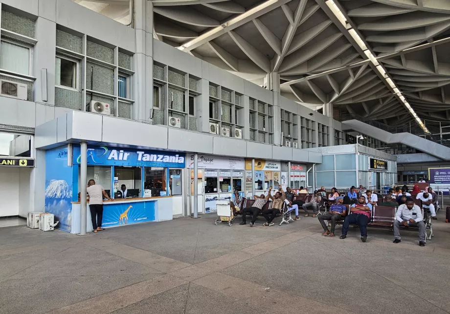 Comptoirs des compagnies aériennes devant le hall des départs